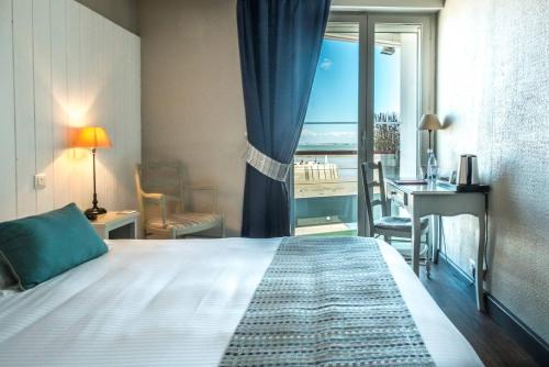 a bedroom with a bed and a view of the ocean at Hôtel de La Marée - Face à l'océan - Ile de Ré in Rivedoux-Plage