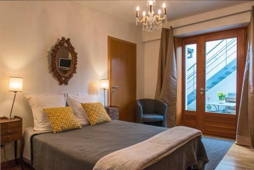 1 dormitorio con 1 cama con espejo y silla en Chambres d'Hôtes Rachelle Schneider, en Husseren-les-Châteaux