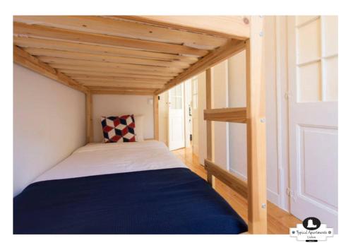 リスボンにあるSupimpa Typical Apartmentの木製の天井が特徴の小さな部屋のベッド1台分です。