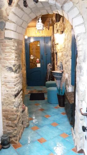 La salle de bains est pourvue d'une porte bleue et d'un mur en pierre. dans l'établissement Casa il Soffio di Eolo, à Scilla