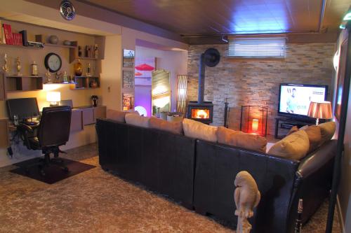 a living room with a large couch and a television at Gîte Chez Baza in Shawinigan