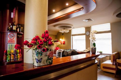 un bar con un jarrón de flores en un mostrador en Villa Brussels, en Deva