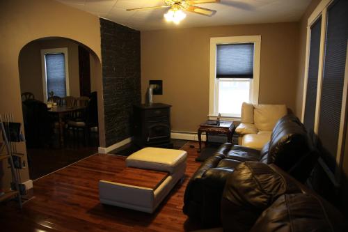 a living room with a leather couch and a table at Charming Home Near Ski Areas in Rumford