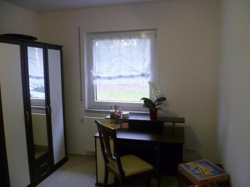 a room with a desk and a window with a table and a chair at Ferienhaus Charme in Grabowhöfe