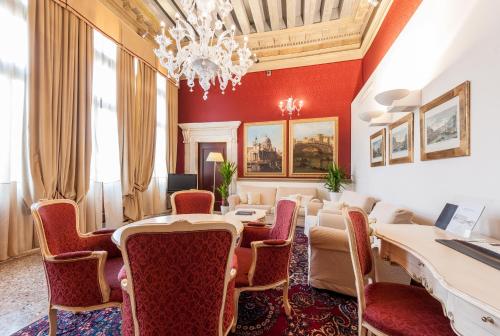a room with a table and chairs and a chandelier at Ruzzini Palace Hotel in Venice
