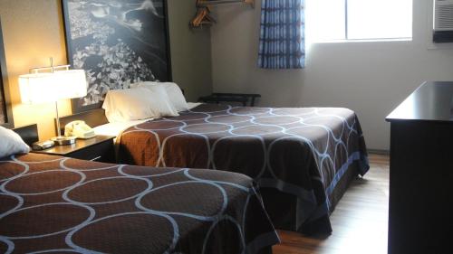 a hotel room with a bed and a table with a lamp at Super 8 by Wyndham Cortez/Mesa Verde Area in Cortez