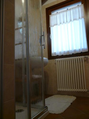 a shower stall in a bathroom with a window at B&B LA Garzetta in Adria