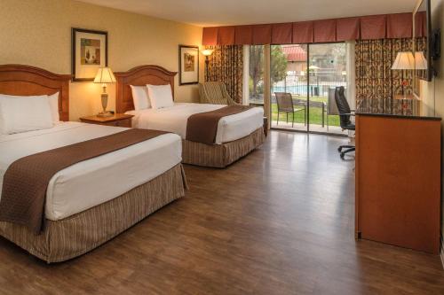 a hotel room with two beds and a balcony at Red Lion Hotel Pasco Airport & Conference Center in Pasco