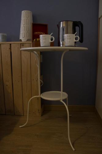 a table with two cups and a coffee pot on it at Albergo Felice in Sottomarina