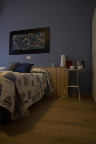 a bedroom with a bed with a blanket and a table at Albergo Felice in Sottomarina