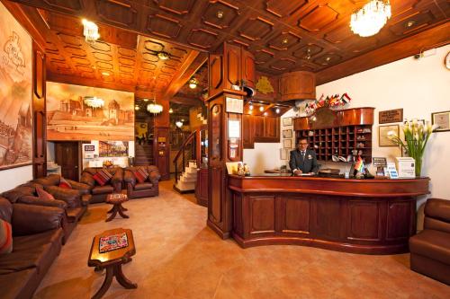 a man standing behind a bar in a living room at Hotel Mabey Cusco in Cusco