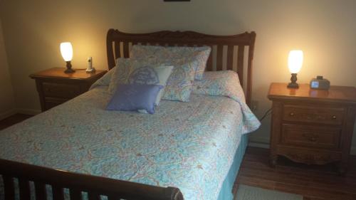 una camera con un letto con due comodini e due lampade di Pelican Inlet E130 a Crescent Beach