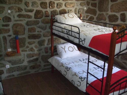 two bunk beds in a room with a stone wall at Casa Velha in Avelal