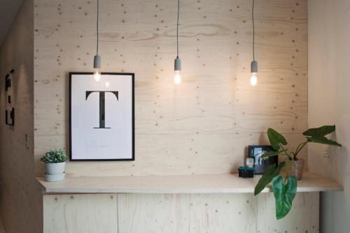 a table with a picture of the letter t on a wall at Talo Urban Rooms in Donostia-San Sebastián
