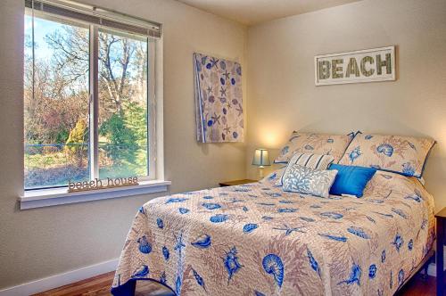 een slaapkamer met een bed met blauwe kussens en een raam bij Allee Beach House in Westport