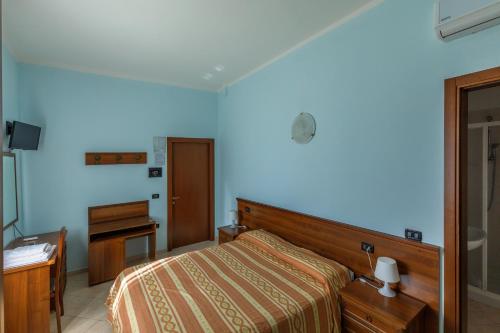una camera con letto, cassettiera e scrivania di AlloggiItalia a Porto Tolle