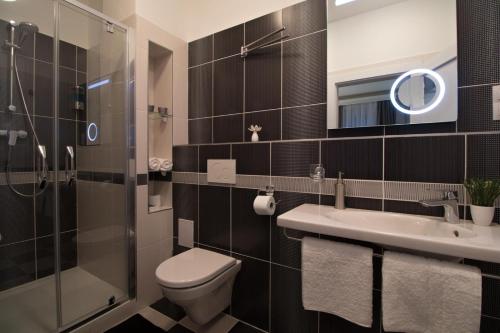 a bathroom with a toilet and a sink and a shower at Residence Vaclavska in Prague