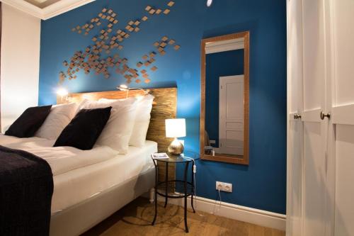 a bedroom with a white bed with a blue wall at Residence Vaclavska in Prague