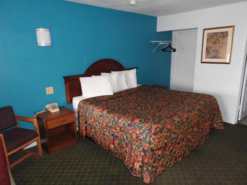 a hotel room with a bed and a chair at Mayo Inn in Roswell