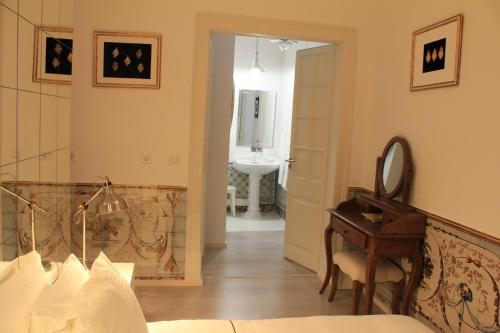 a bedroom with a mirror and a desk and a sink at Lisbon Downtown Inn in Lisbon