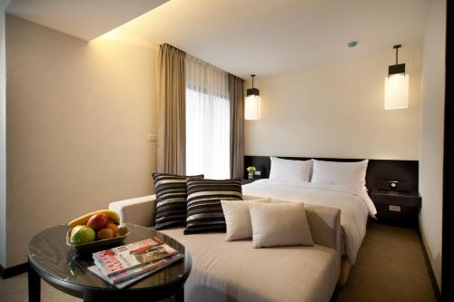 a hotel room with two beds and a couch at The Corner House in Taipei