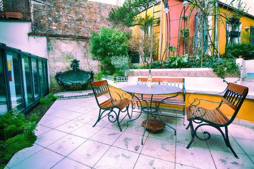 a patio with a table and chairs on a patio at Paris-Oasis "All Inclusive" in Paris