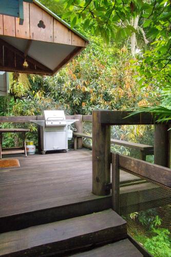 a wooden deck with a picnic table and benches at Mt Glorious Getaways in Mount Glorious
