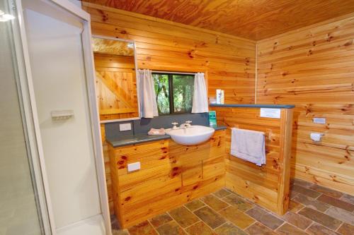 un bagno con lavandino in una baita di tronchi di Mt Glorious Getaways a Mount Glorious