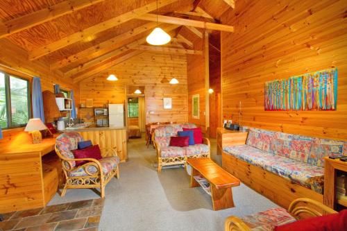 a living room of a cabin with wooden walls at Mt Glorious Getaways in Mount Glorious
