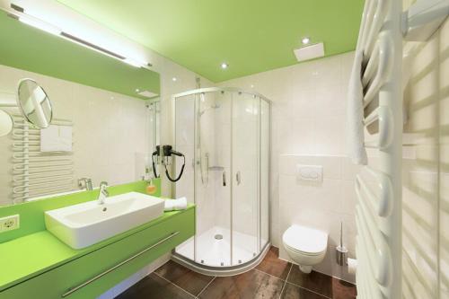 a bathroom with a shower and a sink and a toilet at Landhotel Föhrenhof Ellmau in Ellmau