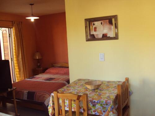 Cette chambre comprend une table, un lit et un miroir. dans l'établissement Cabañas del Molle, à Valle Hermoso