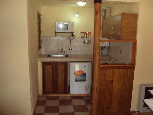 a small kitchen with a sink and a refrigerator at Cabañas del Molle in Valle Hermoso