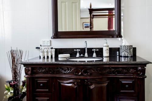 a bathroom vanity with a sink and a mirror at Bli Bli House Riverside Retreat in Twin Waters