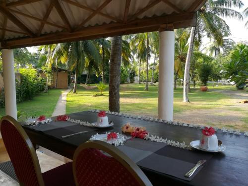 a black table with flowers on top of it at Villa Gaetano Unawatuna in Unawatuna