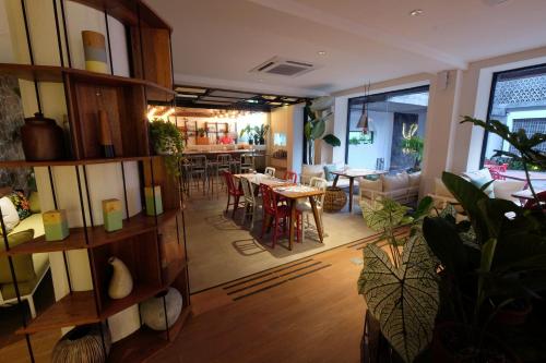 a living room with tables and chairs and a kitchen at YATS Colony in Yogyakarta