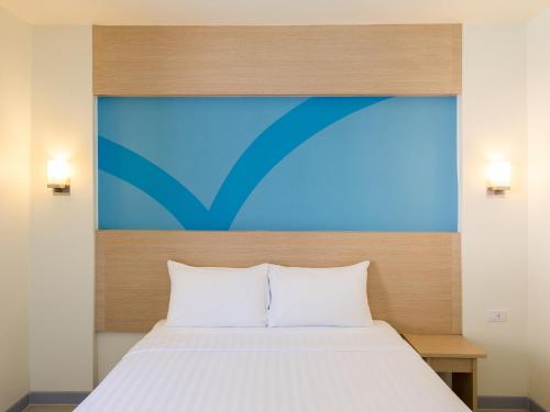 a bedroom with a bed with a large headboard at HOP INN Surat Thani in Surat Thani