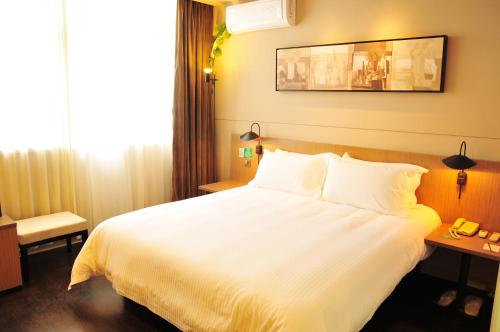 a hotel room with a white bed and a window at JinJiang Inn Wujiang Tongli Yunli Bridge in Suzhou