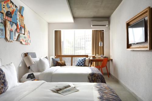 a hotel room with two beds and a window at YATS Colony in Yogyakarta