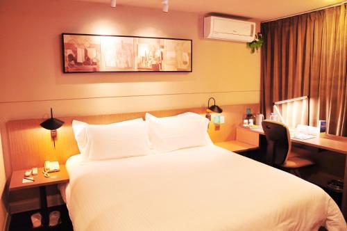 a hotel room with a large bed and a desk at JinJiang Inn Wujiang Tongli Yunli Bridge in Suzhou