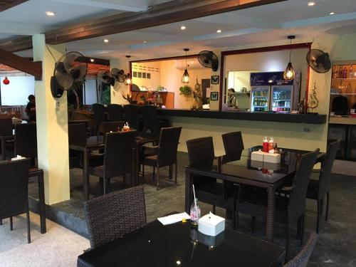 a restaurant with tables and chairs and a bar at Cocco Resort in Pattaya South