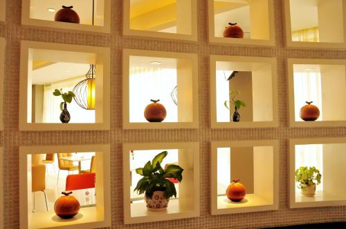 a collage of mirrors on a wall with plants at JinJiang Inn Wujiang Tongli Yunli Bridge in Suzhou