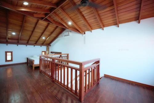a large room with wooden floors and a wooden ceiling at Cardamon Hotel Nilaveli in Nilaveli