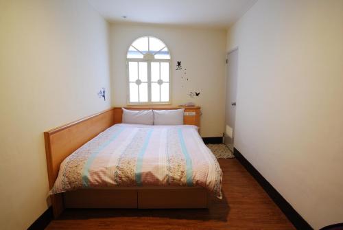 Schlafzimmer mit einem großen Bett und einem Fenster in der Unterkunft Sun Ho Inn in Taipeh