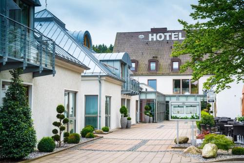 a hotel with a courtyard in front of a building at Sporthotel Fuchsbachtal in Barsinghausen