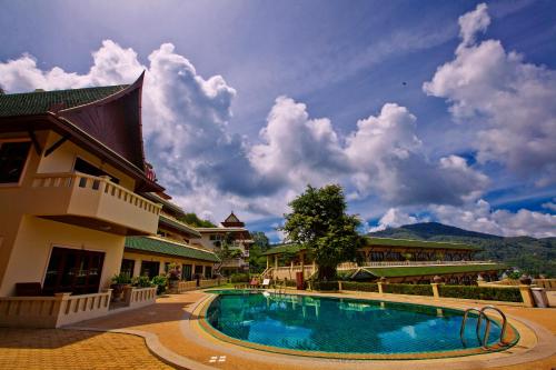 a swimming pool in front of a building at Prince Edouard Apartments & Resort Patong Beach Phuket in Patong Beach