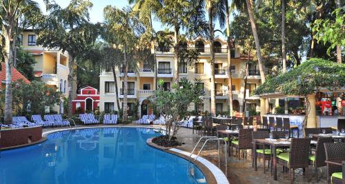 a hotel with a swimming pool and tables and chairs at Park Inn by Radisson Goa Candolim in Candolim