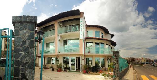 un grand bâtiment avec des fenêtres en verre sur une rue dans l'établissement Hotel Lozite, à Sozopol