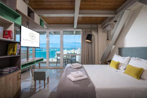 a bedroom with a bed with a view of the ocean at Infinity City Boutique Hotel in Heraklio Town