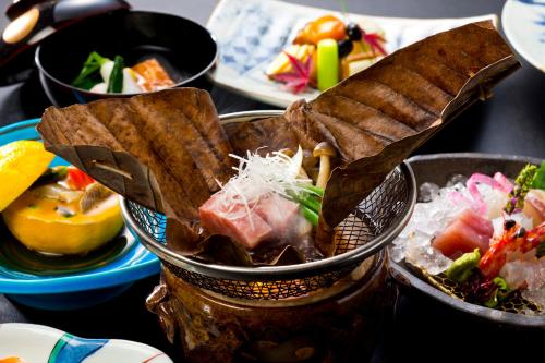 a table topped with bowls of food on a table at 山荘 風の杜 Sanso Kazenomori in Minoo