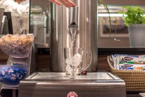 a person is making a drink in a blender at Akzent Hotel Köhler in Gießen